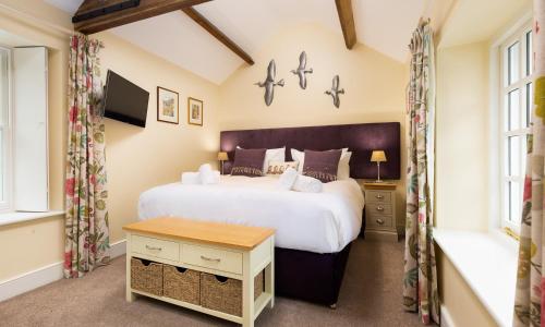 um quarto com uma cama grande e uma mesa em Scots Pine em Keswick