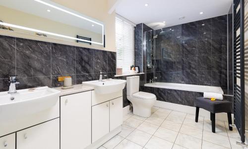 a bathroom with a sink and a toilet and a tub at Scots Pine in Keswick