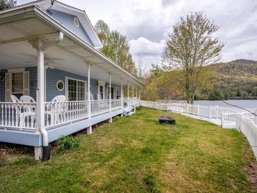 a house with a porch and chairs on the lawn at stayNantahala - Smoky Mountain Cabins in Aquone