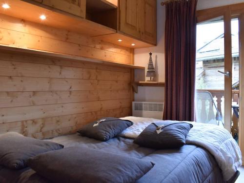 une chambre avec un lit avec des oreillers dessus dans l'établissement Charmant Studio Rénové pour 3 Personnes à Méribel, Proche Pistes et Commerces, Balcon Sud - FR-1-180-33, à Méribel