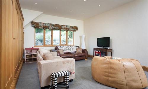 a living room with two couches and a tv at The Old Coach House in Troutbeck