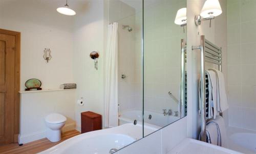 a bathroom with a tub and a shower and a toilet at The Old Coach House in Troutbeck
