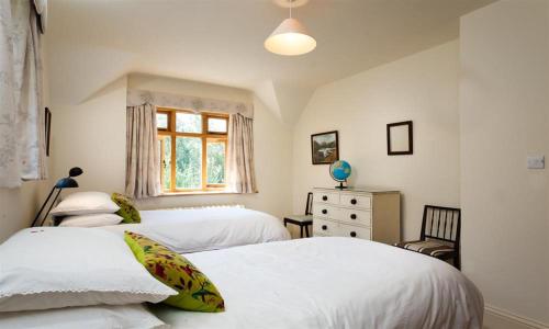 a bedroom with two beds and a window at The Old Coach House in Troutbeck