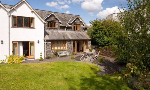 a large white house with a garden and a lawn at The Old Coach House in Troutbeck