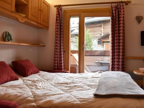 une chambre avec un lit et une porte coulissante en verre dans l'établissement Studio rénové au pied des pistes, balcon sud, 3 pers., Méribel - FR-1-180-32, à Méribel