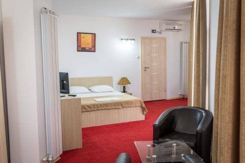 a bedroom with a bed and a desk and a chair at Live Tulcea Hotel in Tulcea