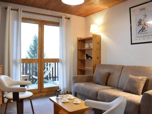 un salon avec un canapé et une table dans l'établissement Appartement cosy avec balcon, proche pistes et commerces - Méribel - FR-1-180-66, à Méribel