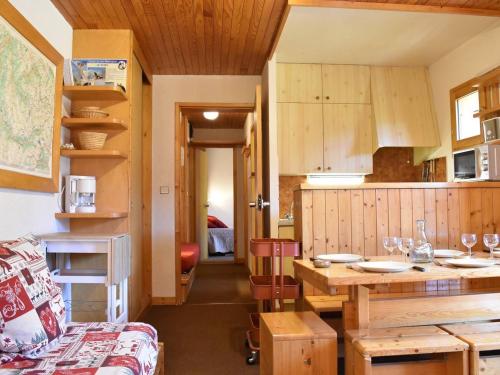 une cuisine avec des placards en bois et une table dans l'établissement Appartement cosy 2P à Méribel, 5 pers, proche pistes et commerces, parking inclus - FR-1-180-92, à Méribel