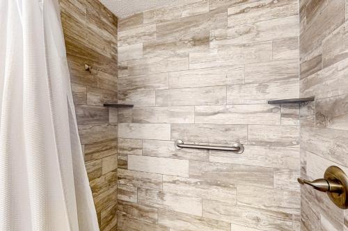 a bathroom with a shower with a stone wall at Top of the Gulf 702 Teal Waters in Panama City Beach