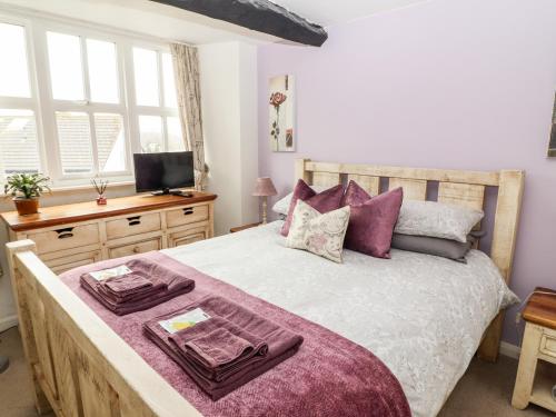 アンブルサイドにあるButtonhole Cottageのベッドルーム1室(大型ベッド1台、紫色の枕付)