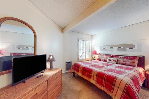a bedroom with a bed and a flat screen tv at Sherwin Villas 12 B in Mammoth Lakes