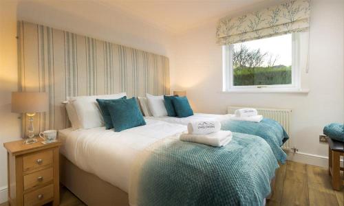 a bedroom with two beds and a window at Lanterns At Grasmere in Grasmere