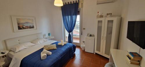 - une chambre avec un lit doté de draps bleus et une fenêtre dans l'établissement Il Balconcino, à Naples