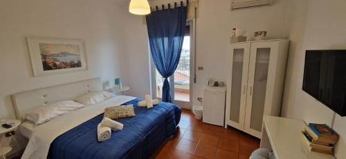 a bedroom with a bed with blue sheets and a window at Il Balconcino in Naples