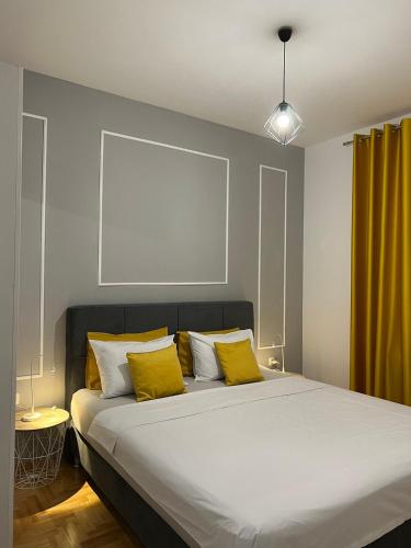 a bedroom with a large bed with yellow pillows at Apartman Divine in Banja Luka