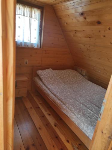 a small room with a bed in a log cabin at Vila Carobna suma Tara in Bajina Bašta