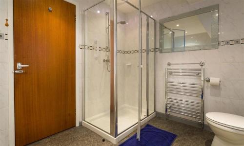 a bathroom with a shower and a toilet and a mirror at Fairhaven in Bowness-on-Windermere