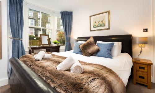 um quarto com uma cama grande e toalhas em Oak Cottage em Bowness-on-Windermere