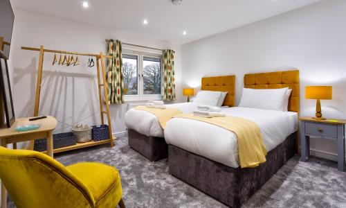 a bedroom with a large bed and a yellow chair at Wynford in Ambleside