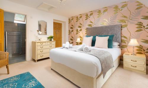 a bedroom with a large bed and a bathroom at Fairfield Cottage in Grasmere