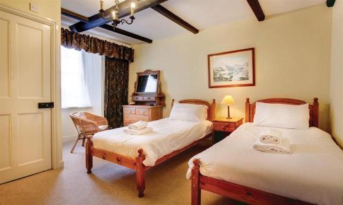 a bedroom with two beds and a television in it at Scafell in Ambleside