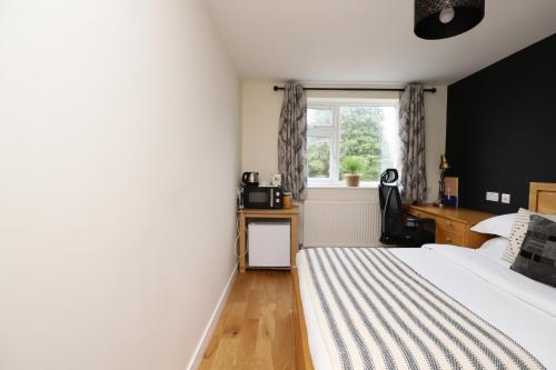 a bedroom with a bed and a window at Luxurious double bedroom, ensuite with free Wifi. in Oxford