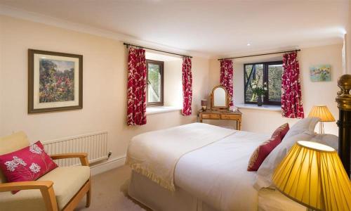 a bedroom with a bed and a chair and windows at River Falls View in Ambleside