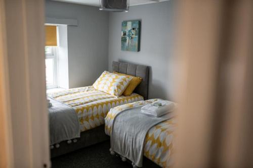 - une chambre avec 2 lits et une fenêtre dans l'établissement 2 Bed Sleeps 4 Central Haverfordwest Town House, à Pembrokeshire