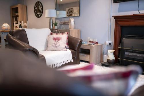 a living room with a chair with a pillow at 2 Bed Sleeps 4 Central Haverfordwest Town House in Pembrokeshire
