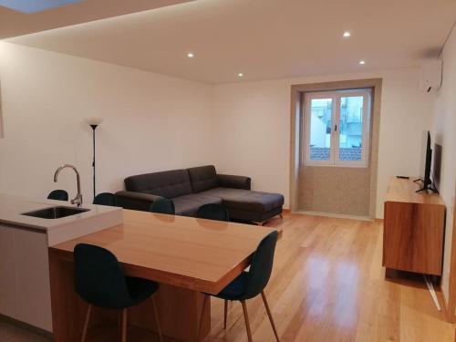 a living room with a table and a couch at Garrett Houses in Póvoa de Varzim