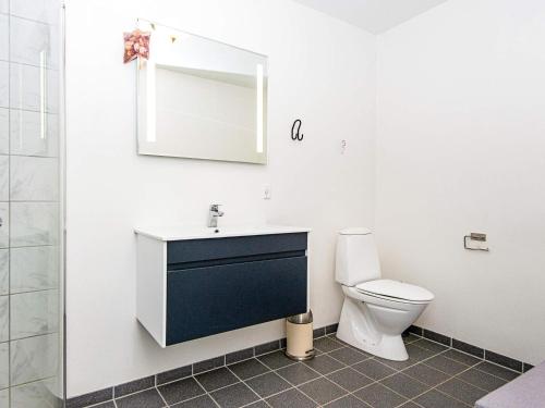a bathroom with a toilet and a sink and a mirror at Holiday home Nørre Snede in Nørre Snede