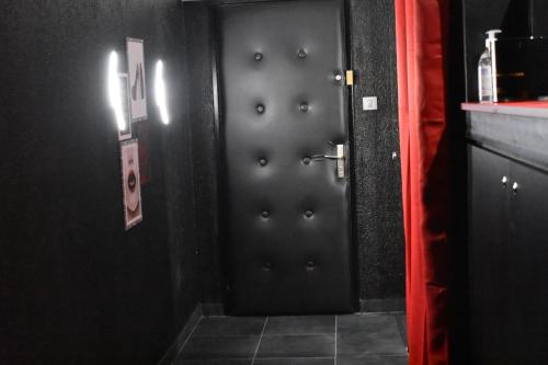 La salle de bains est pourvue de deux portes en métal avec des yeux. dans l'établissement L’Escale du Donon « Le Temple de Cupidon », à Grandfontaine