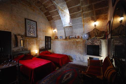 a room with two beds and a tv in it at Kapadokya Ihlara Konakları Otel Konak Odaları in Guzelyurt