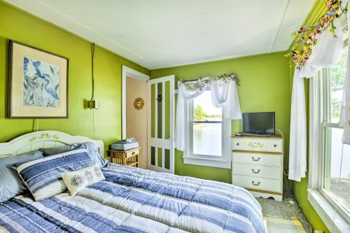 a bedroom with green walls and a bed and a television at Waterfront Wellesley Island Getaway with Deck! in Fineview