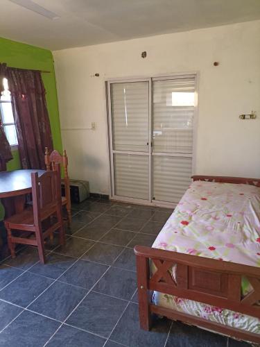 a bedroom with a bed and a table and a window at Departamentos Temporarios Aeropuerto in Formosa