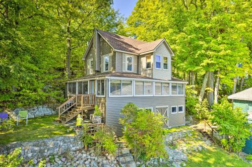 a large house on a hill with trees at Waterfront Wellesley Island Getaway with Deck! in Fineview