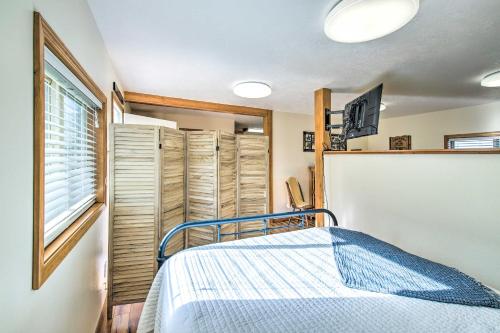 a bedroom with a bed and a window with shutters at Cozy Cottage Studio Stunning Mountain Views! in Hamilton