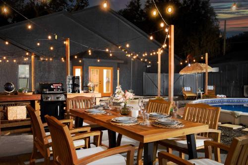 a wooden table and chairs in a patio with lights at Private Pools and Hot Tubs Luxe Brandon Oasis! in Brandon