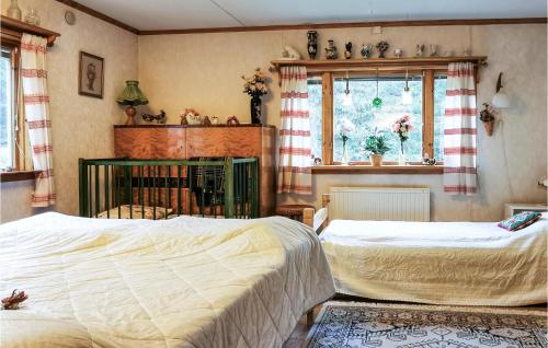 a bedroom with two beds and a window at Beautiful Home In Lnneberga With 2 Bedrooms in Lönneberga