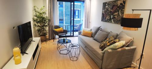 a living room with a couch and a television at Strada-Beach Las Canteras in Las Palmas de Gran Canaria