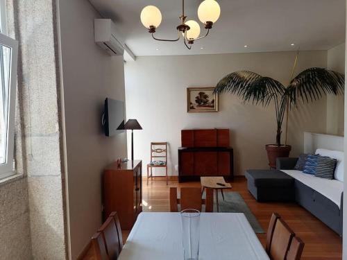 a living room with a table and a couch at Garrett Houses in Póvoa de Varzim