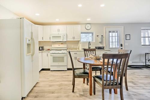 a kitchen with white cabinets and a table and chairs at Charming Beacon Apt with Fire Pit Near Hiking! in Beacon