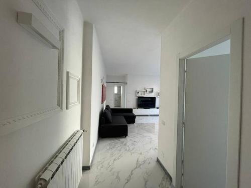 uma sala de estar com um sofá preto e um corredor em Centoventinove em Carrara