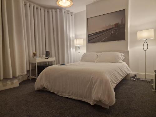 a bedroom with a large bed and a table with a laptop at Beautiful Rooms in London in London