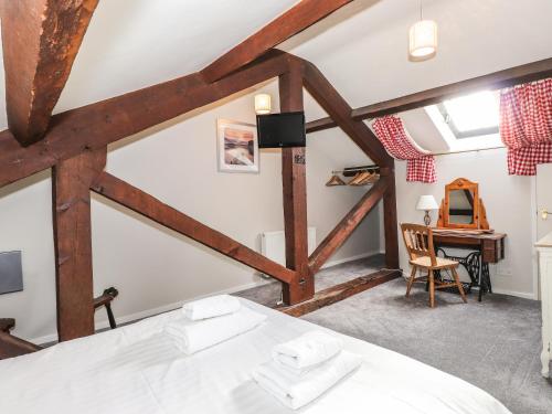 アンブルサイドにあるCandleberry Cottageのベッドとデスクが備わる客室です。