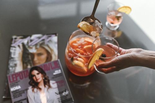 a person holding a glass with a fruit cocktail at Garni hotel BARUT in Šabac