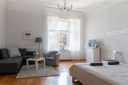 ein Wohnzimmer mit einem Sofa und einem Stuhl in der Unterkunft Budapest Apartment in Budapest