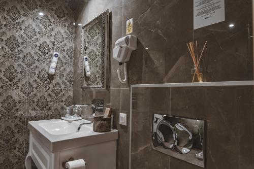 a bathroom with a sink and a phone on the wall at Garni hotel BARUT in Šabac