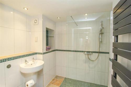 uma casa de banho branca com um lavatório e um chuveiro em The Miller em Ambleside