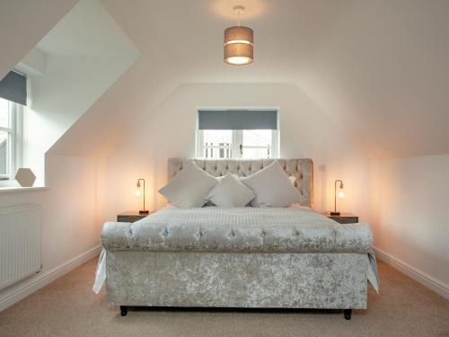 um quarto com uma cama grande e uma janela em Crosshill Cottage em Honiton